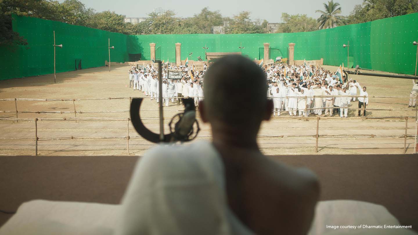 An on-set green screen stands in for the background during Gandhi's speech